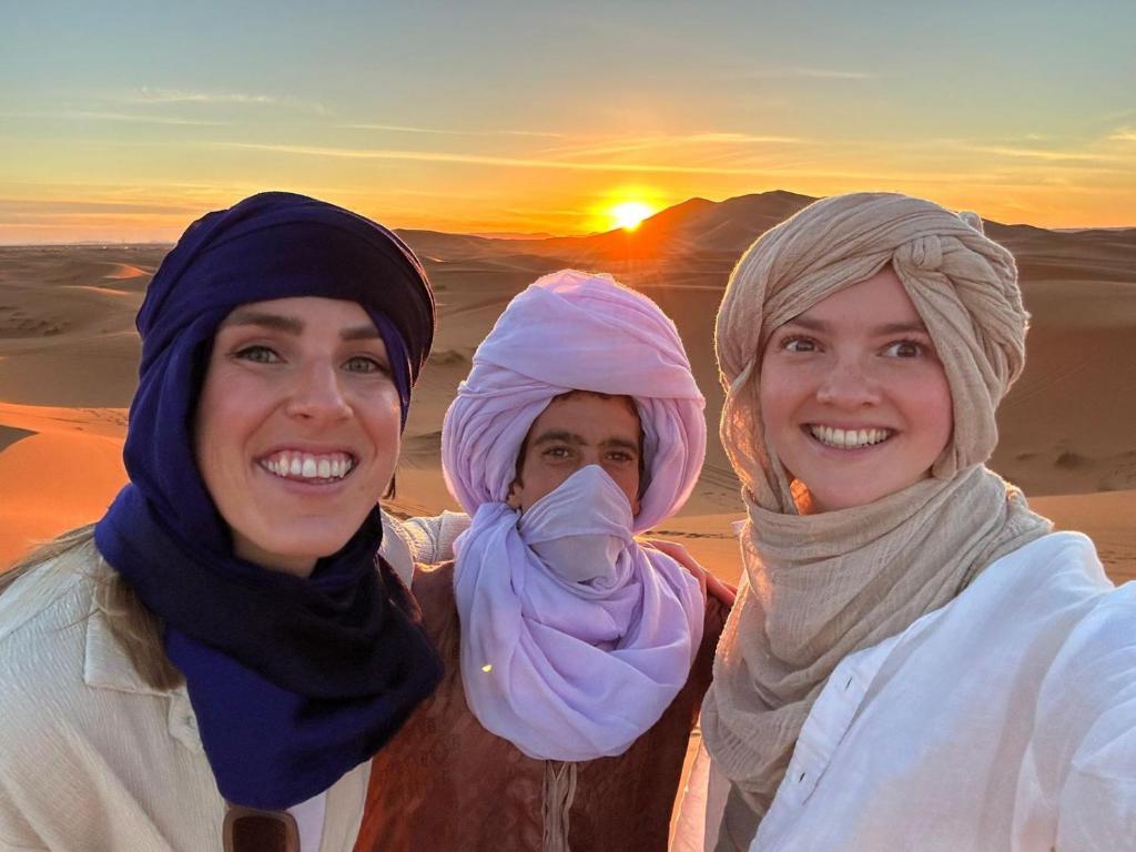een groep van drie vrouwen in de woestijn bij Desert Backpackers Camp in Merzouga