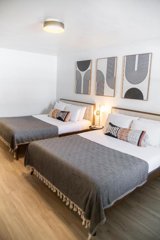 two beds in a hotel room with two bedsvisor at High Creek Lodge and Cabins in Pagosa Springs