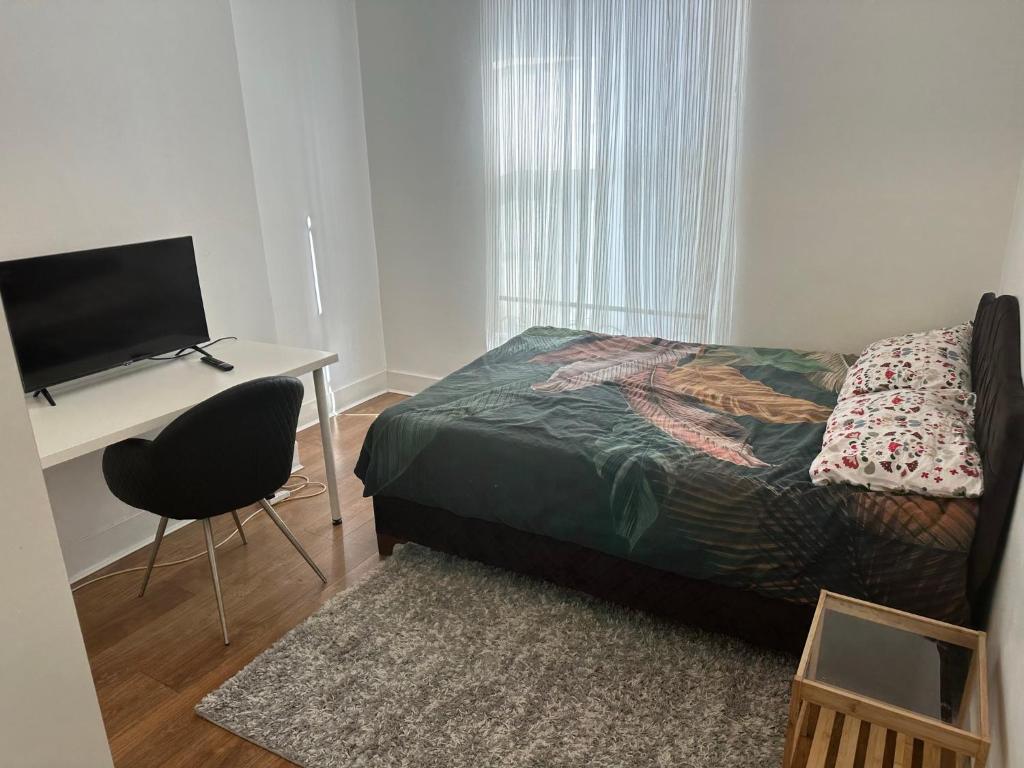 Schlafzimmer mit einem Bett und einem Schreibtisch mit einem TV in der Unterkunft Private room in London
