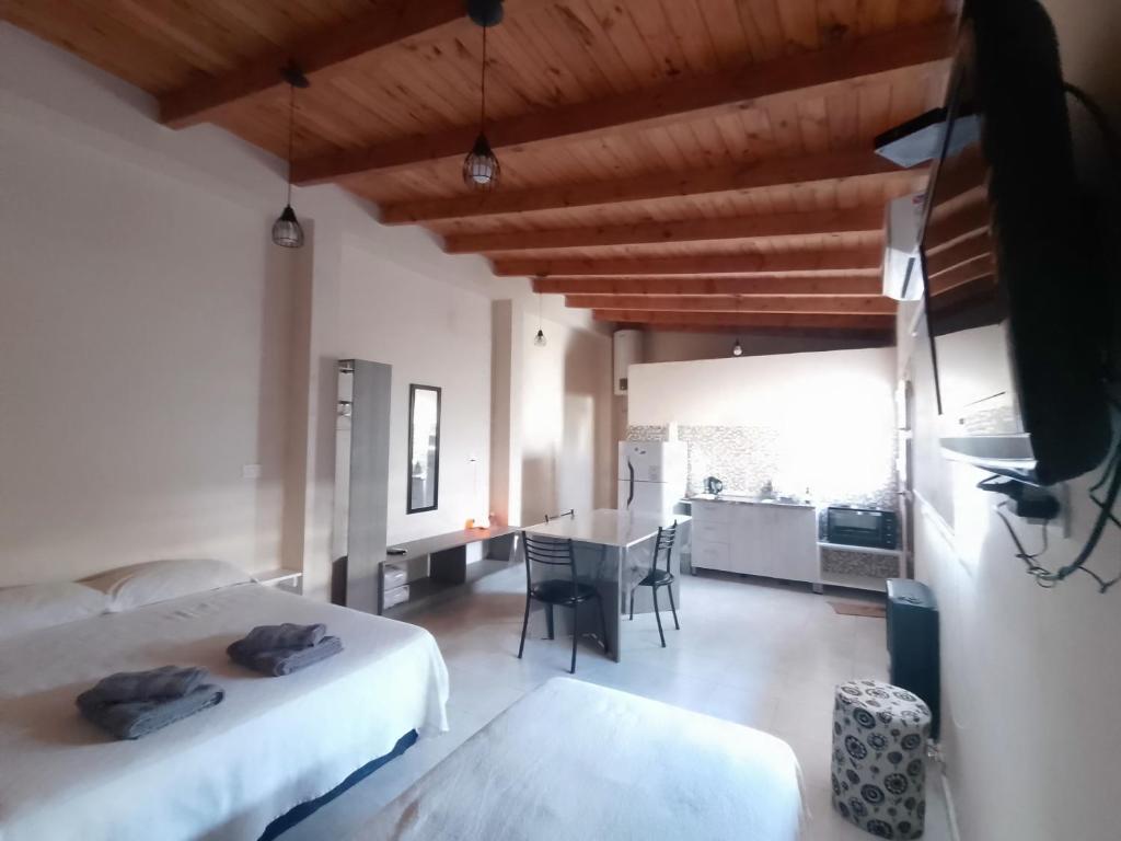 una camera con due letti e un tavolo e una cucina di Venezia-Monoambiente a Villa Mercedes
