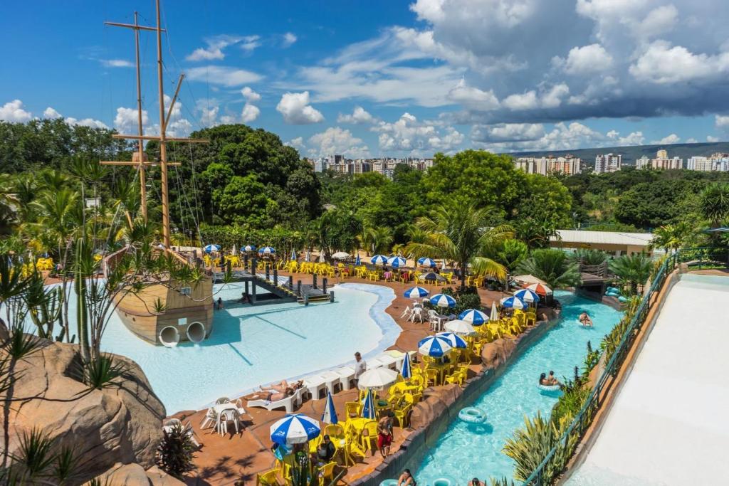 uma piscina num resort com pessoas e guarda-sóis em Piazza diRoma com acesso ao Acqua Park e Splash em Caldas Novas