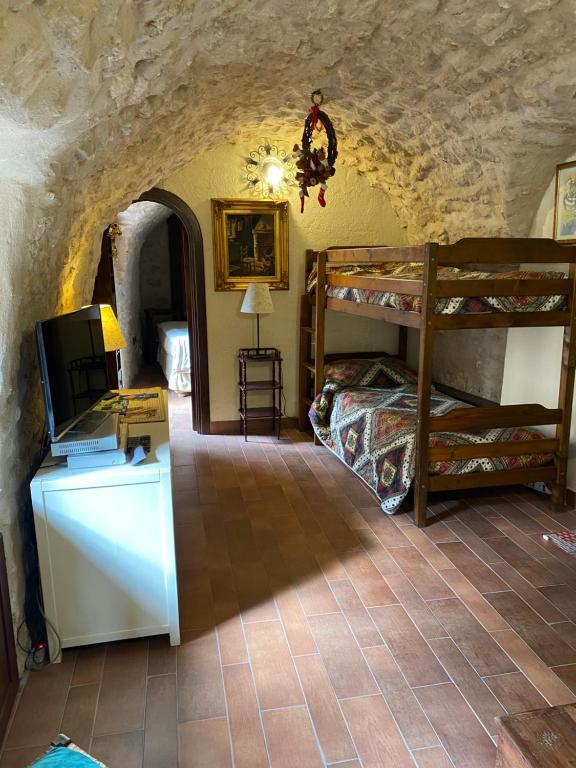 una camera con letto a castello e scrivania con TV di la casa di Sophie a Pettorano sul Gizio