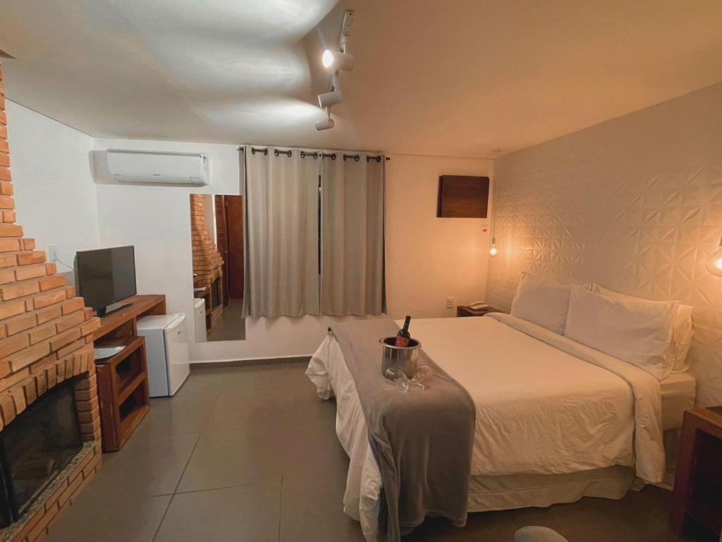 a hotel room with a bed and a television at Hotel Bertell in Penedo