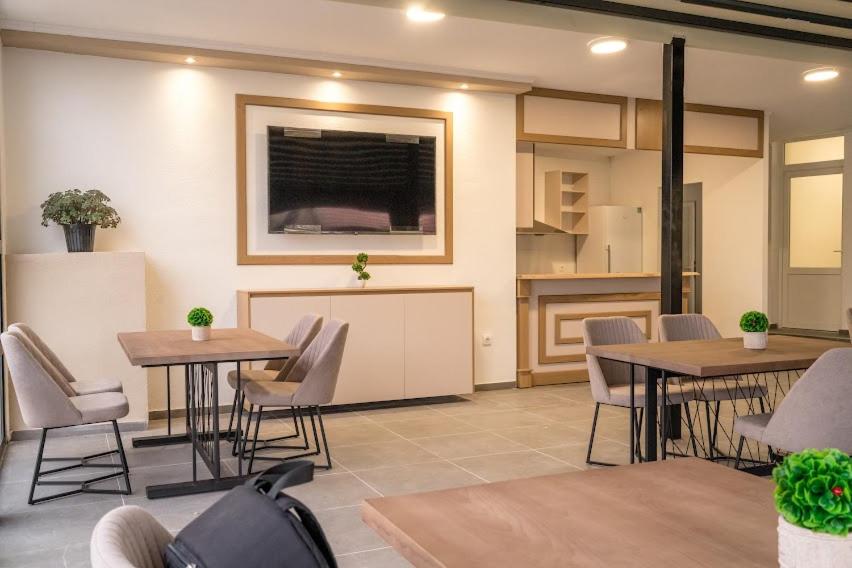 a room with tables and chairs and a kitchen at FENIX Gevgelija in Gevgelija
