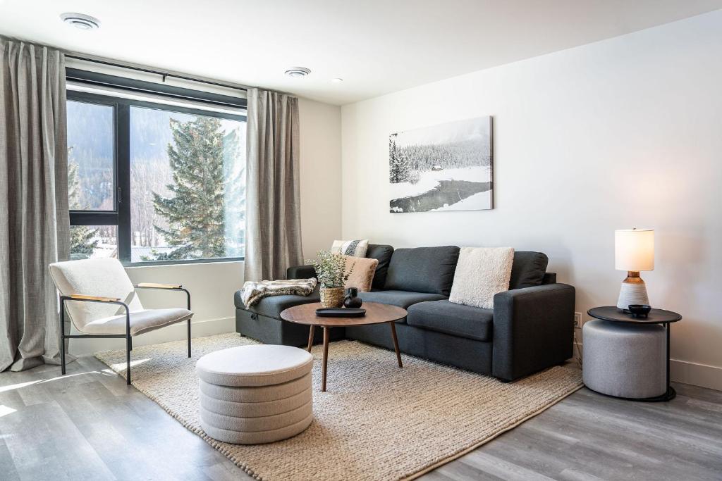 a living room with a couch and a chair at Peaks and Birdies by Revelstoke Vacations in Revelstoke