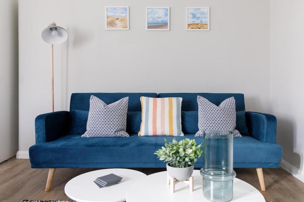 a blue couch in a living room with a table at Little Blue in Chichester