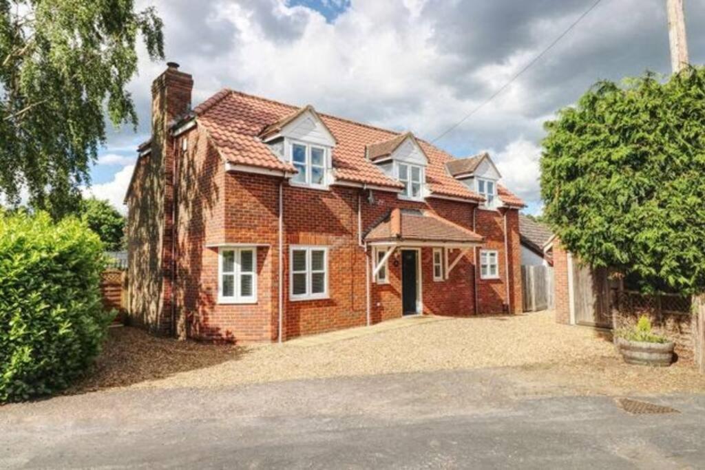 a red brick house with a large driveway at Large detached Cambridgeshire Countryside Home in Wilburton