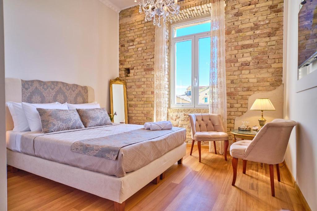 a bedroom with a bed and a table with a chair at Anesis Studios Old Corfu Town in Corfu