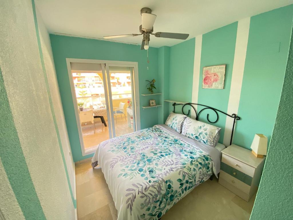 a bedroom with a bed and a ceiling fan at Sea and mountain view Room with pool- Habitación PISO COMPARTIDO para 1 persona in Benalmádena
