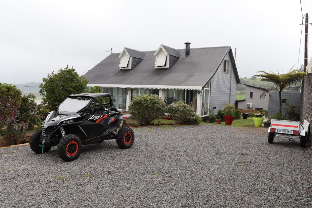 un véhicule à quatre roues garé devant une maison dans l'établissement Entre Volcan et Montagnes, à La Plaine des Cafres