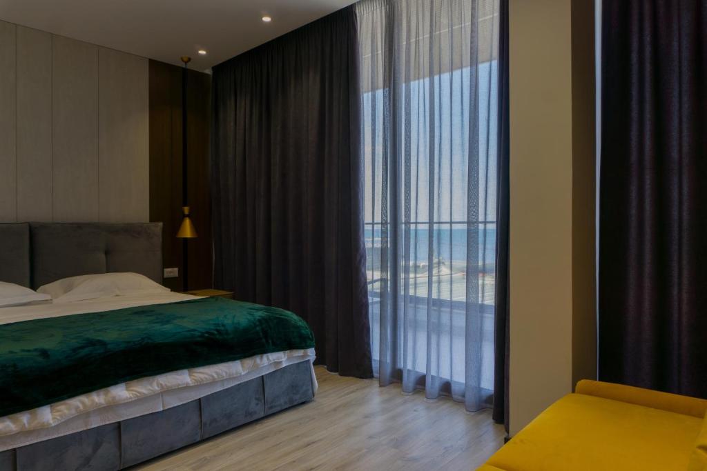 um quarto com uma cama e uma janela grande em Hotel Morfeus em Durrës