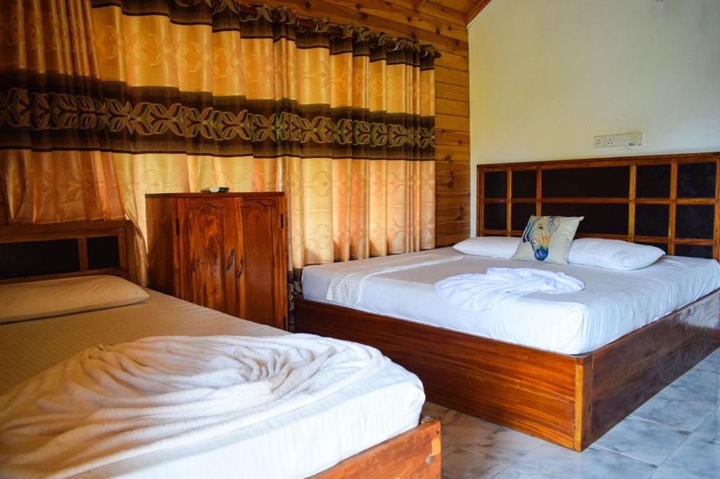 a bedroom with two beds in a room at Mithra Paradise Beach Hotel in Nilaveli