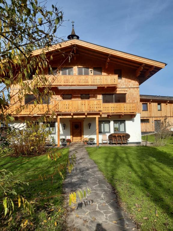 a large wooden house with a pathway in front of it at Schörghof in Abtenau