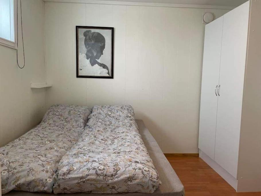 1 cama en un dormitorio con una foto en la pared en Sentral og koselig leilighet, en Tromsø