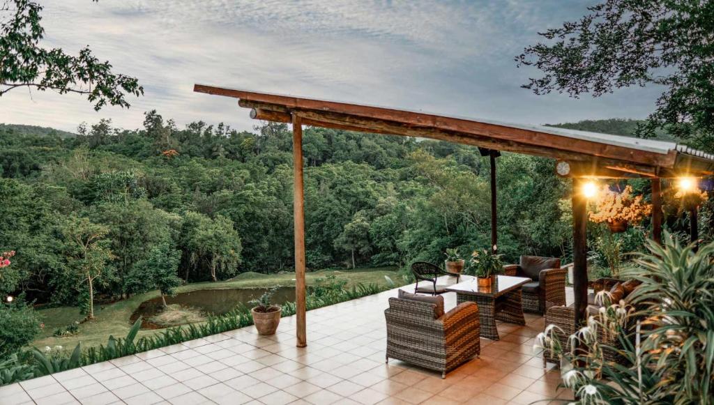 a patio with a table and chairs and a view at Bushbaby Valley Lodge in Hazyview