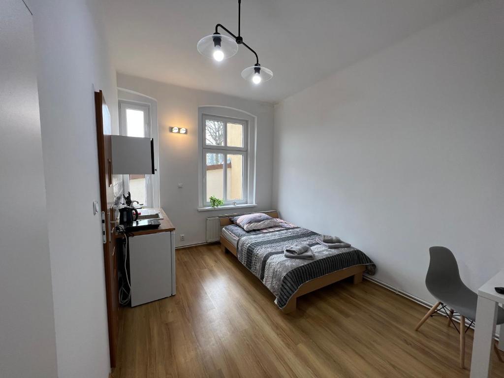 - une chambre avec un lit, un bureau et une fenêtre dans l'établissement Apartament Chrobrego 30/3, à Zielona Góra