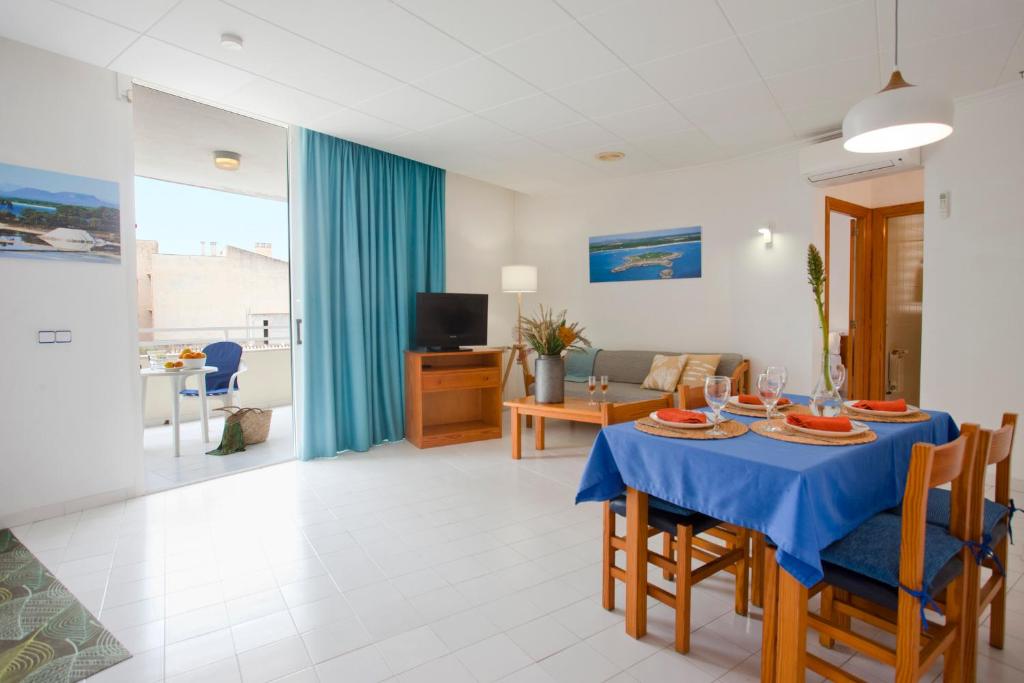 a dining room and living room with a blue table at Apartamento Es Trenc 2 in Colonia Sant Jordi