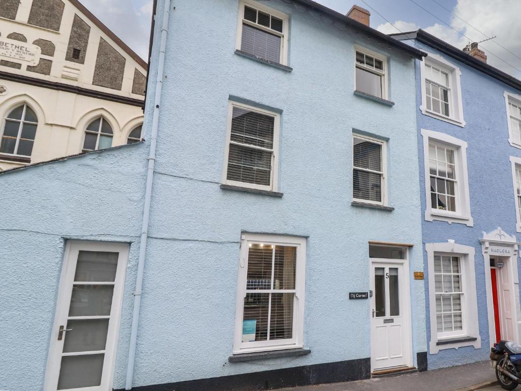 um edifício azul com janelas brancas numa rua em Ty Cornel em Aberdyfi