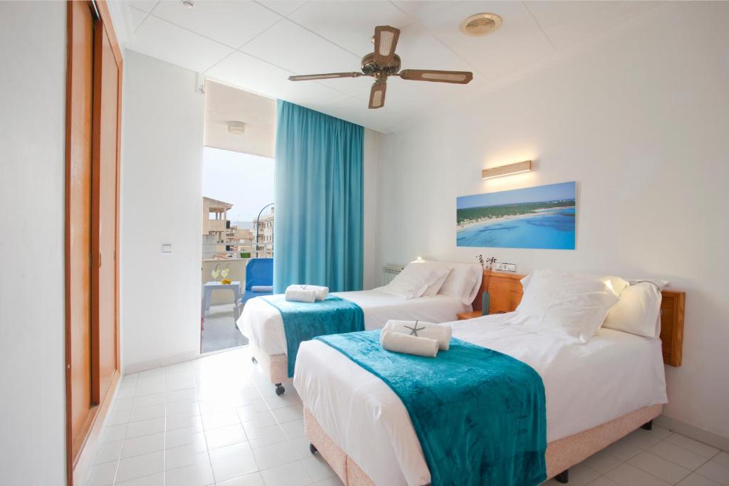 um quarto de hotel com duas camas e uma varanda em Apartamento Es Trenc 1 em Colonia Sant Jordi