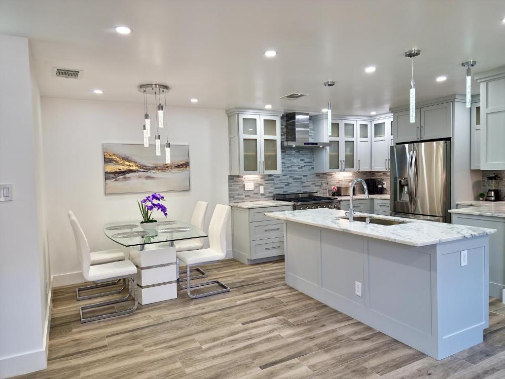 a kitchen with white cabinets and a table and chairs at Cozy modern house - Near SXSW and other events in Austin