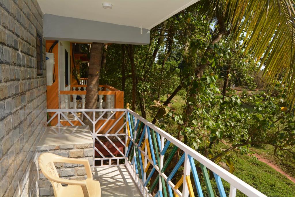 Un balcón de una casa con una silla y árboles en chill out home morjim en Morjim