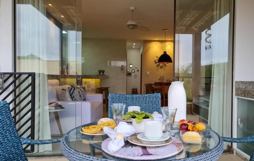 una mesa de cristal con un plato de comida. en Imbassaí Village Solaris, en Imbassai