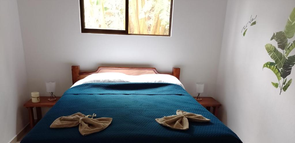 a bedroom with a bed with two mitts on it at Butterfly in Tajo Alto