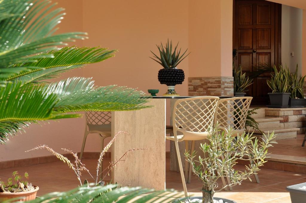 a patio with two chairs and potted plants at Flat with Jacuzzi - Casa Pia in Mondello