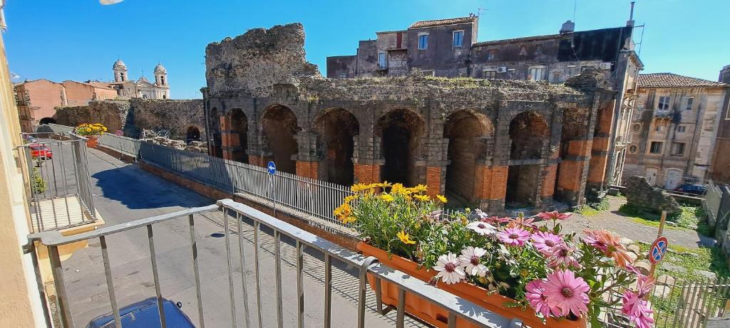 カターニアにあるOdeonHouse - Cataniaのバルコニーから花の咲く建物を望めます。