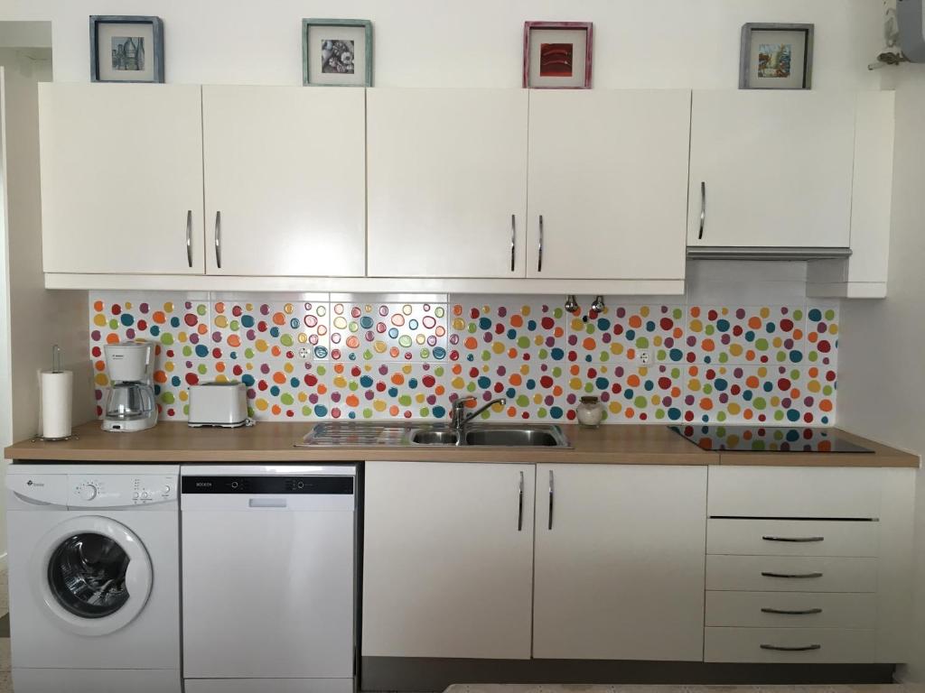 a kitchen with white cabinets and a dishwasher at Stay Porto Côvo II in Porto Covo