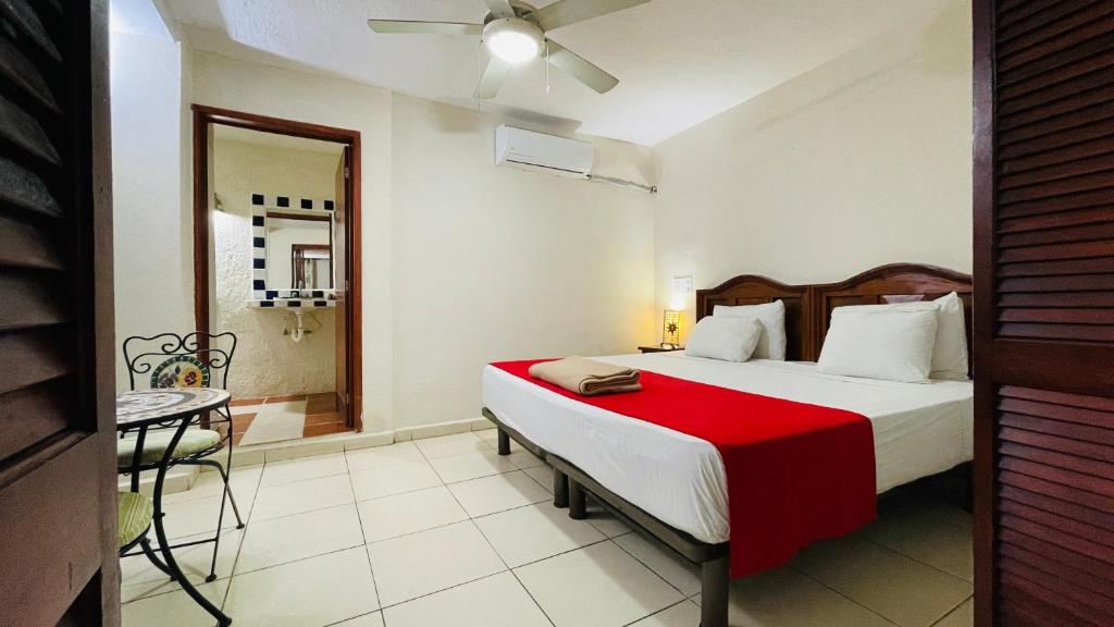 a bedroom with a bed with a red blanket at Hotel B&B - 5th Avenue in Playa del Carmen