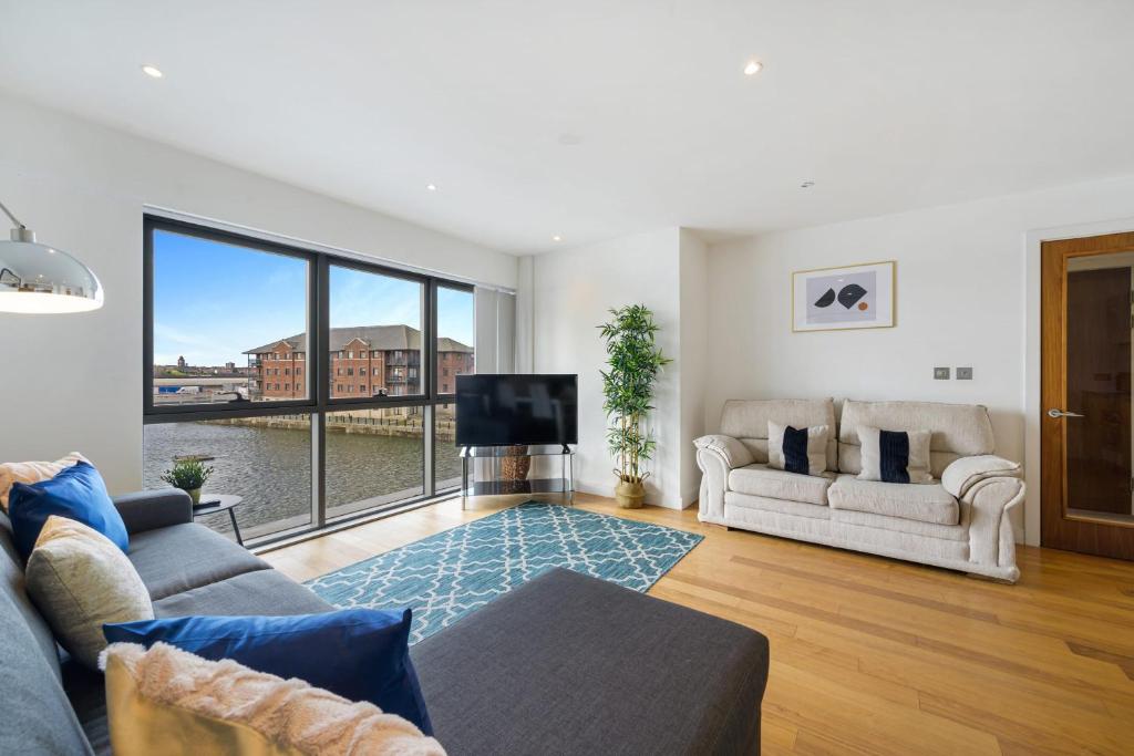 a living room with a couch and a tv at Host & Stay - Waterfront View in Liverpool