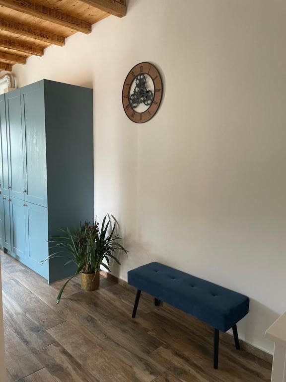 a blue bench in a room with a clock on the wall at Penthouse Damjan in Rab