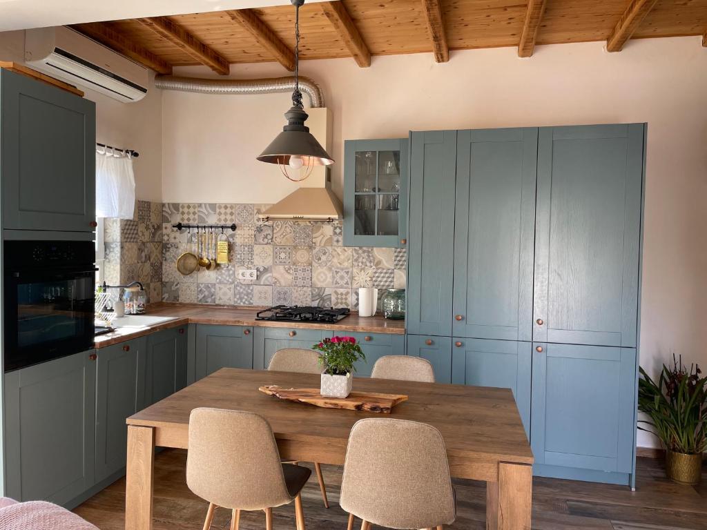 a kitchen with blue cabinets and a wooden table at Penthouse Damjan in Rab
