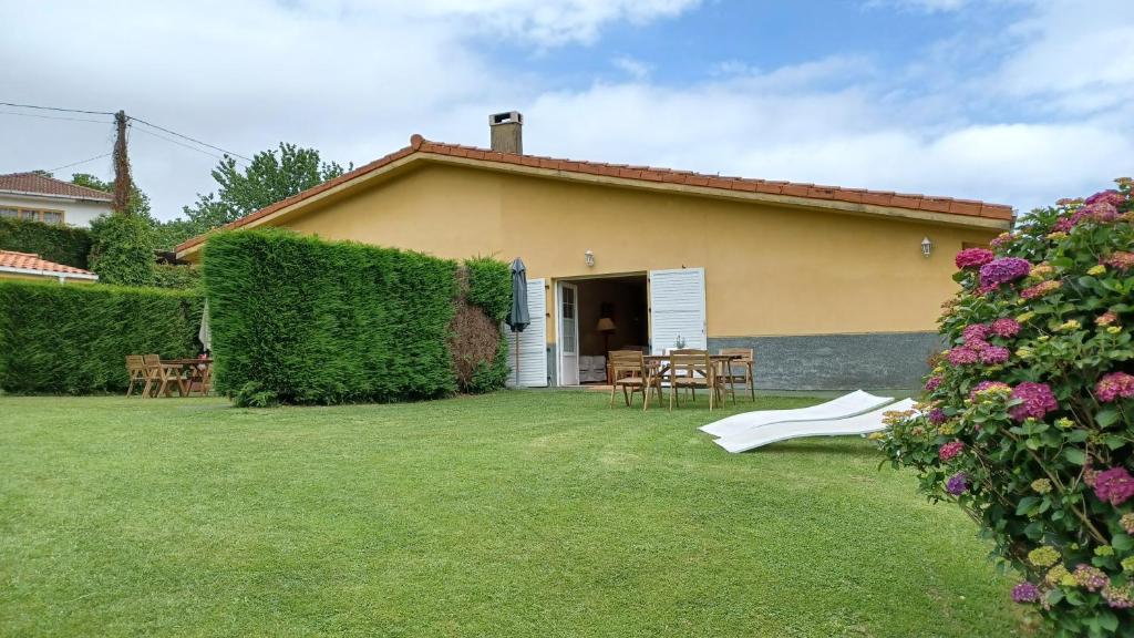 a house with a yard with a table and chairs at Apartamentos El Otero de Cudillero in Soto de Luiña