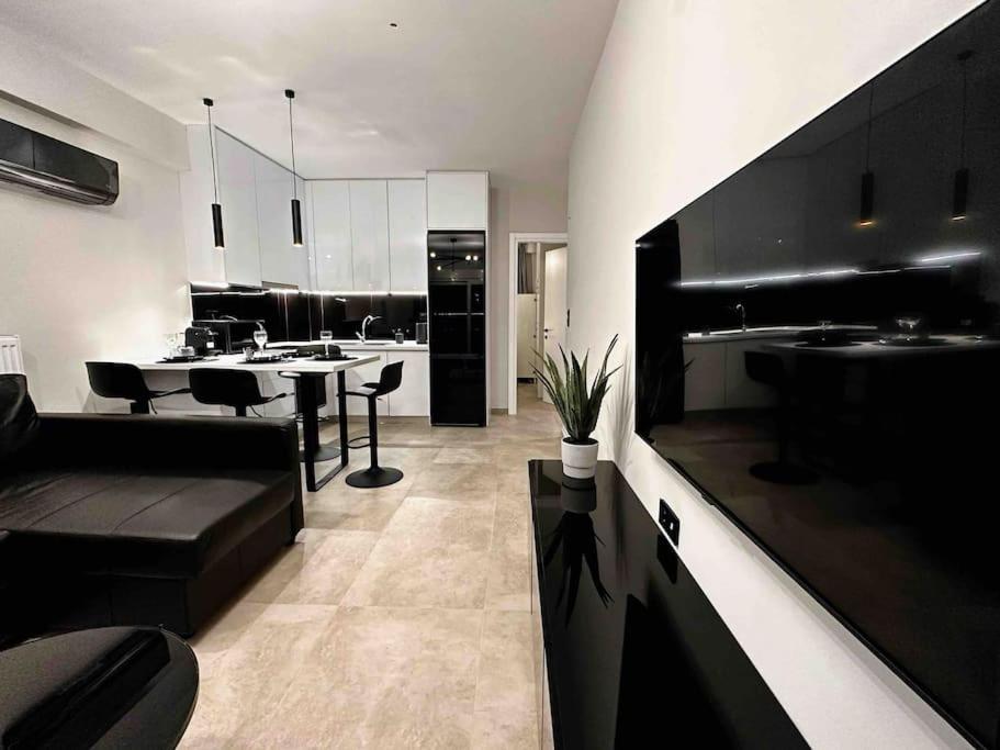 eine schwarz-weiße Küche mit einem Tisch und Stühlen in der Unterkunft Elite Suite with private parking in Kavala