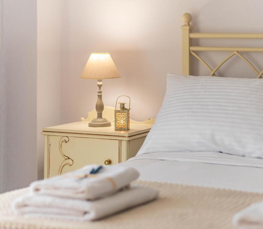 a bed with a lamp on a table with towels at 4keys House 4 in Tripoli