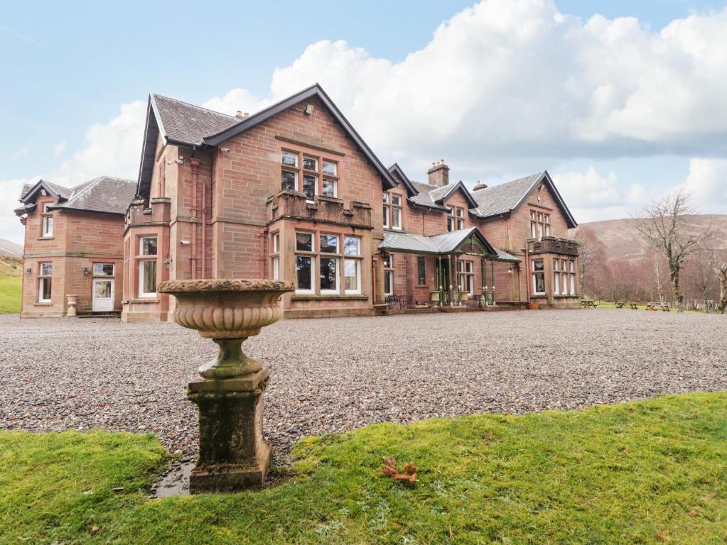 a large house with a fountain in front of it at Ledgowan Lodge Hotel in Achnasheen