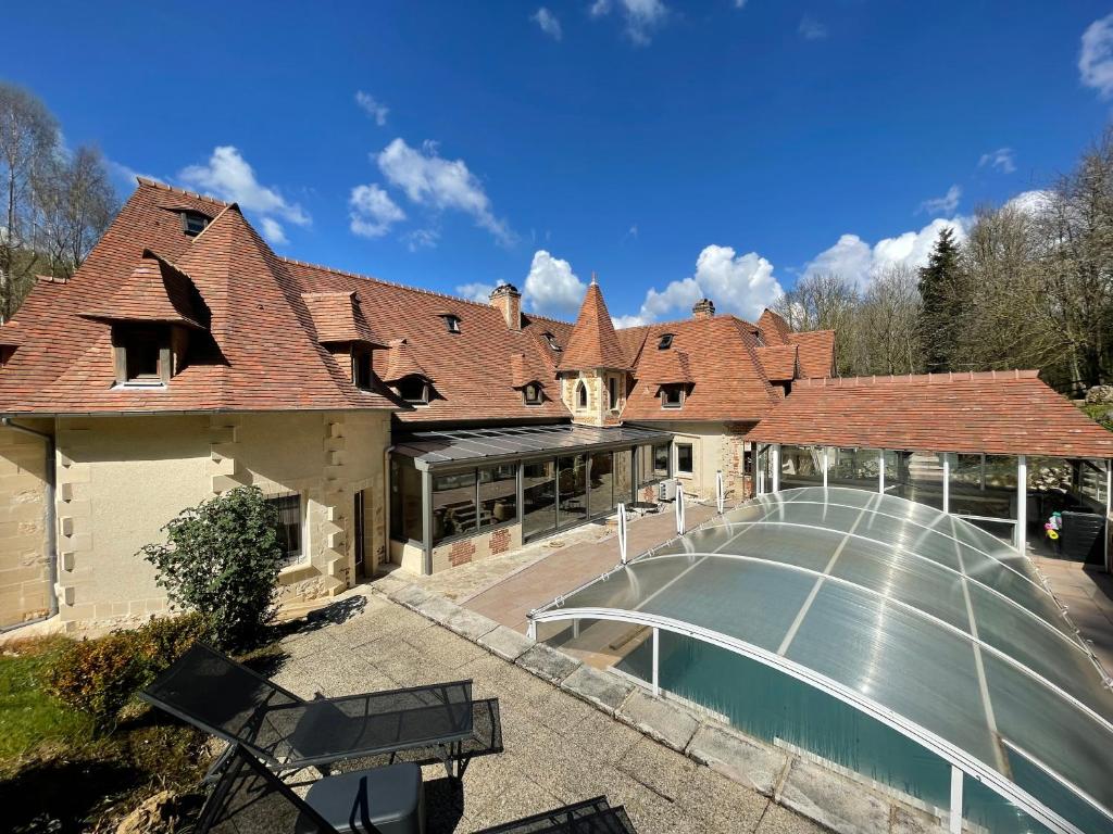 Cette chambre offre une vue sur une maison dotée d'une piscine. dans l'établissement Le prieuré des fontaines, à Les Préaux