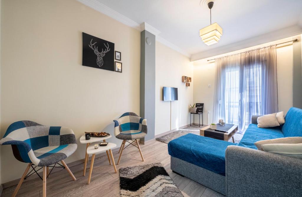 a living room with a blue couch and chairs at T’ Giorgio Apartment in Thessaloniki