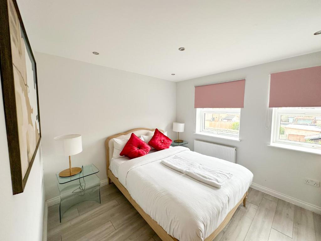 a bedroom with a bed with red pillows on it at 2b Seymour road in Hackbridge