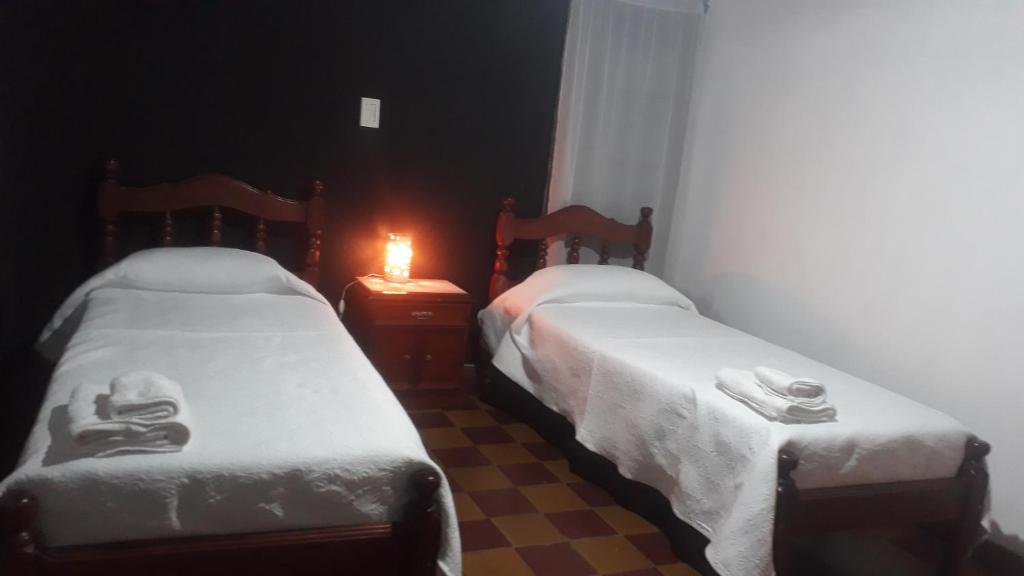 two beds in a room with a candle on a table at Casa kukycita in San Salvador de Jujuy