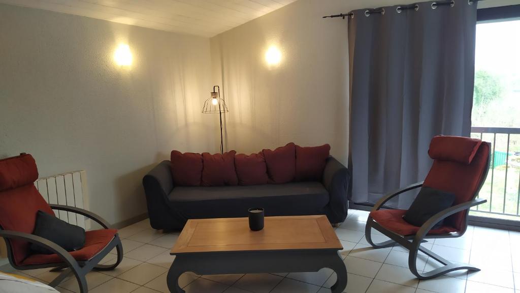 a living room with a couch and chairs and a table at Gite la Péraie - Le Roseau in Treize-Vents