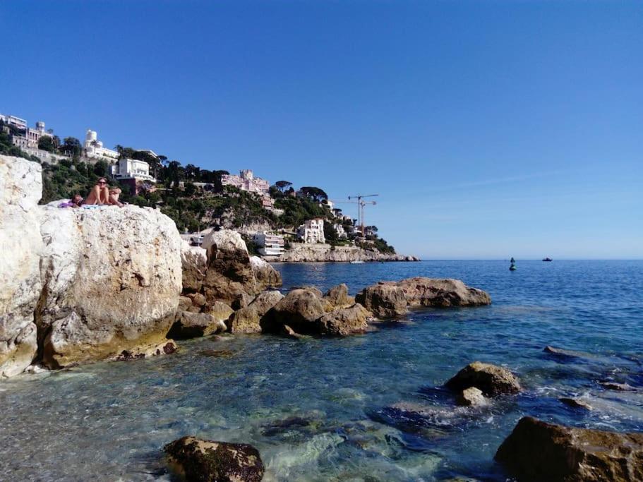 un groupe de personnes assises au sommet d'une plage rocheuse dans l'établissement Studio avec balcon à 7 min du port et de Garibaldi, à Nice