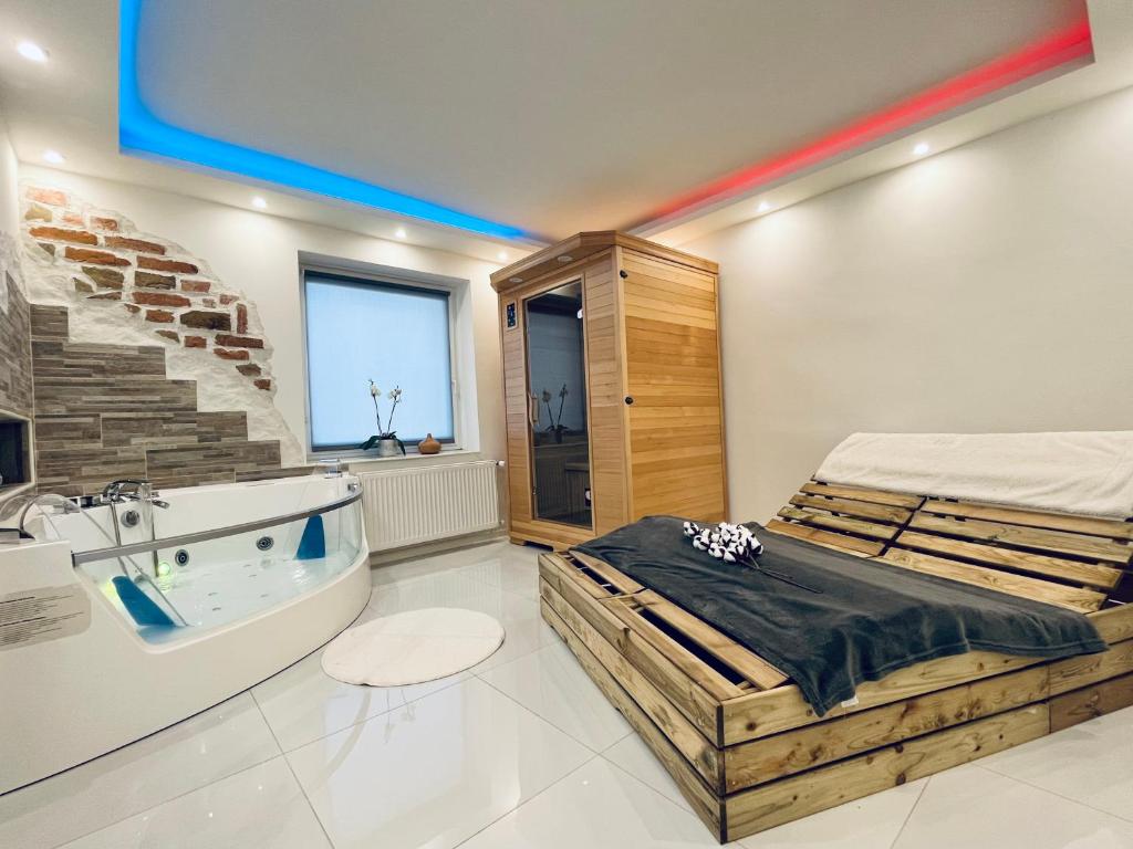 a bedroom with a large bed and a bath tub at Luxe Apartments in Ljutomer