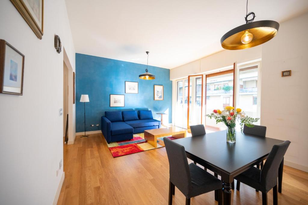 uma sala de estar com uma mesa e um sofá azul em Sunny Park Residence em Florença