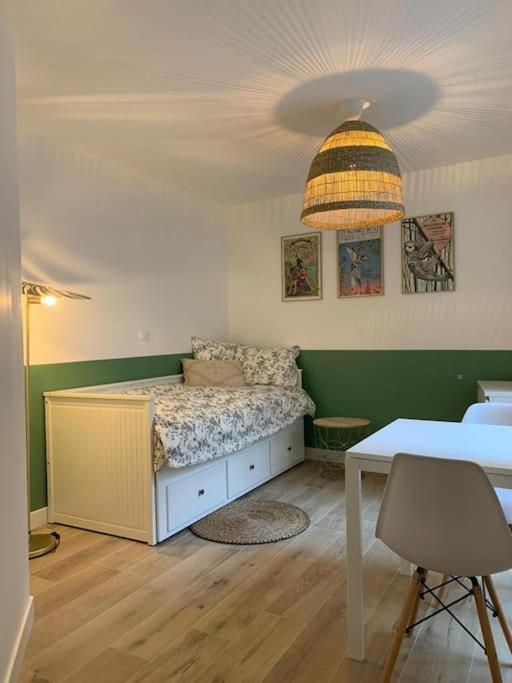 une chambre avec un lit, une table et une lampe dans l'établissement Nantes Bouffay STUDIO Les machines de l'île, à Nantes