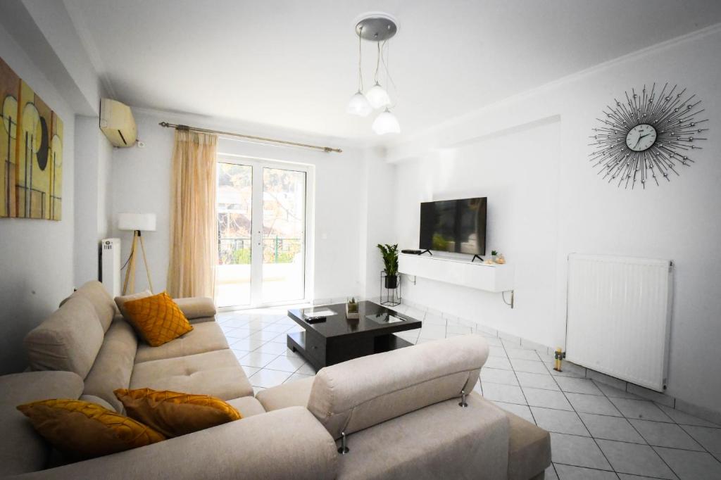 uma sala de estar com um sofá e uma televisão em Joyia's Apartment em Zakynthos Town