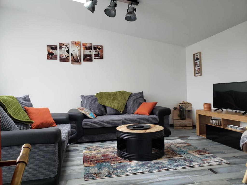 un salon avec deux canapés et une télévision dans l'établissement LE GALET BLANC, à Fouesnant