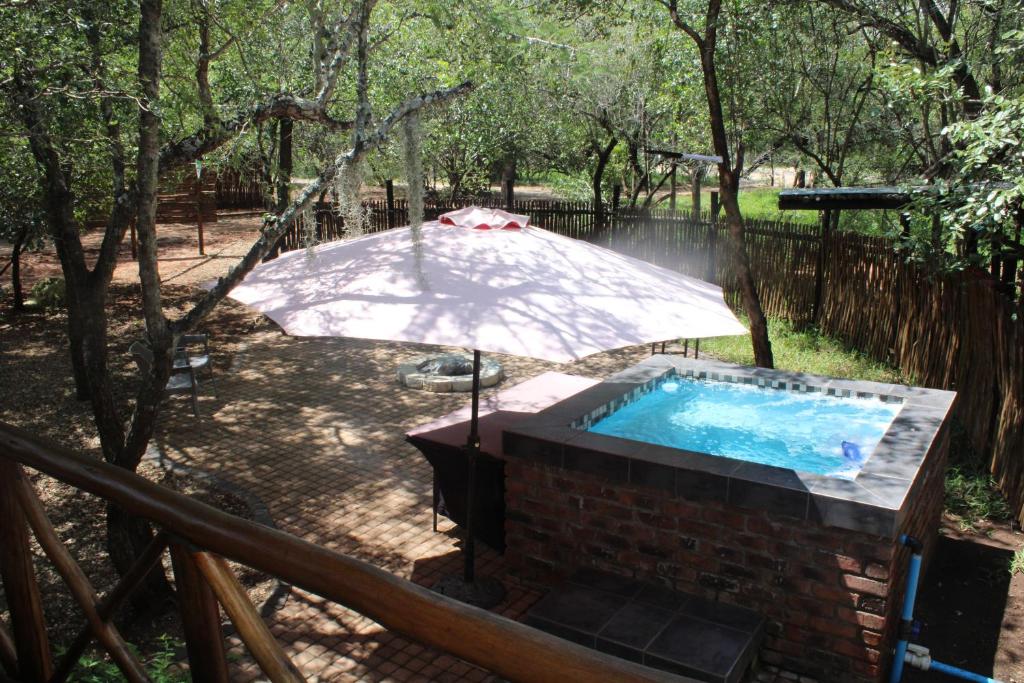een hot tub met een paraplu in de tuin bij Bush break @ 3990 Marloth Park in Marloth Park